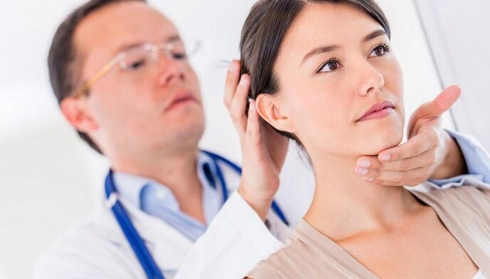 lekarz bada pacjenta z bólem szyi